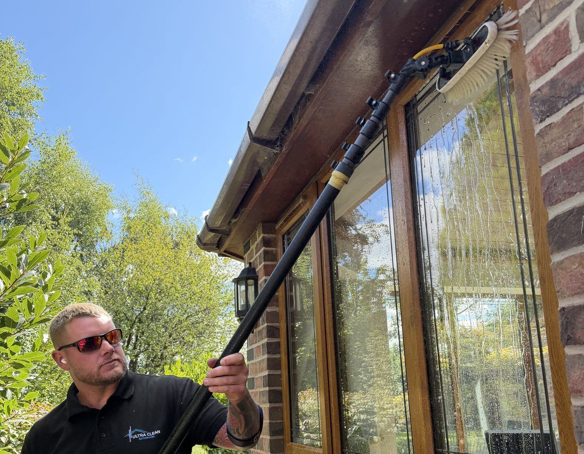 Josh of Ultra Clean Exteriors cleaning a bay window with a water fed pole in Uttoxeter