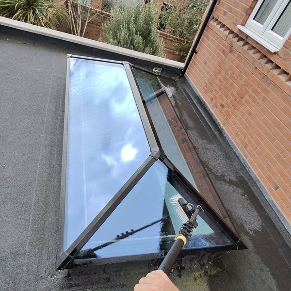 Cleaning the glass of a lantern roof light on a flat roof extension